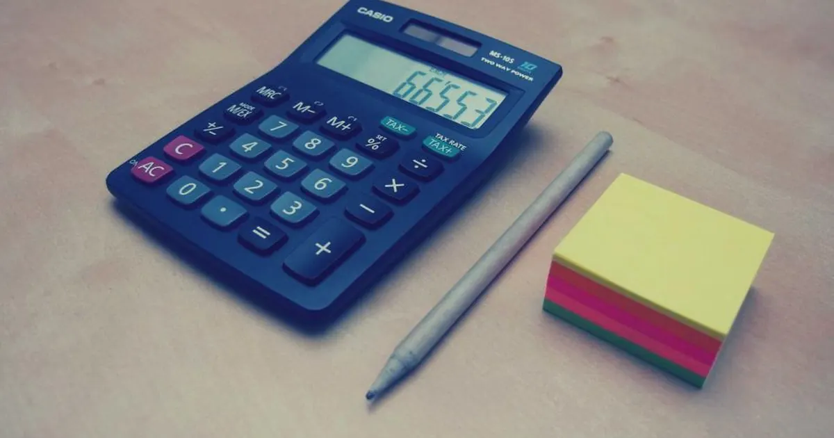 Calculator, pencil and sticky notes on a desk for maths practice