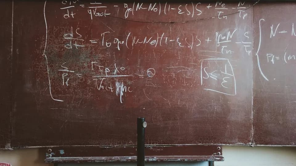 Blackboard covered in handwritten maths equations